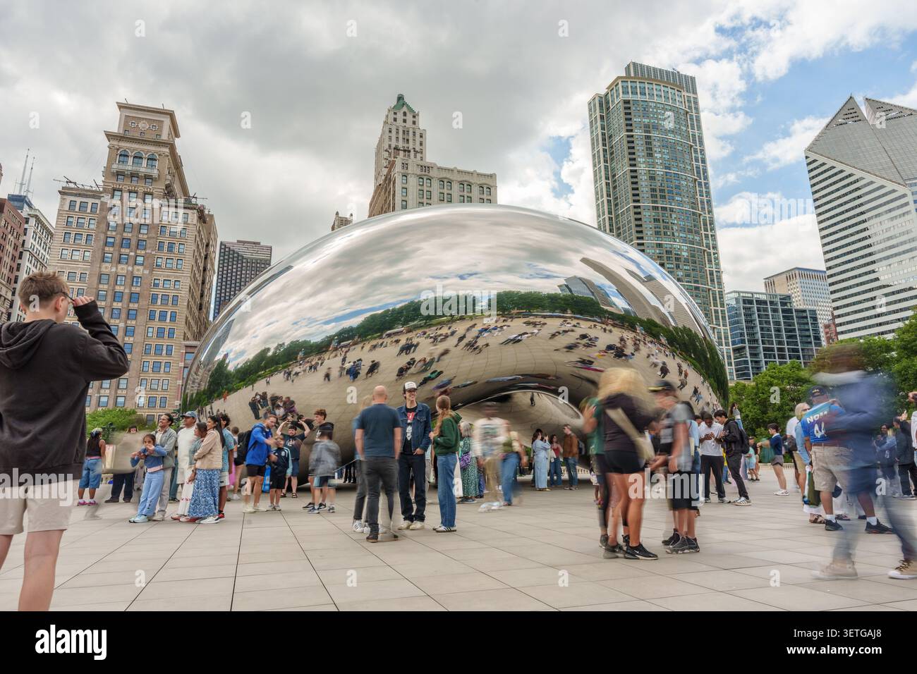 Chicago, Stati Uniti - 19 giugno 2026 - i visitatori si riuniscono intorno all'iconica scultura Cloud Gate di Chicago che riflette lo skyline della città e l'atmosfera vibrante Foto Stock