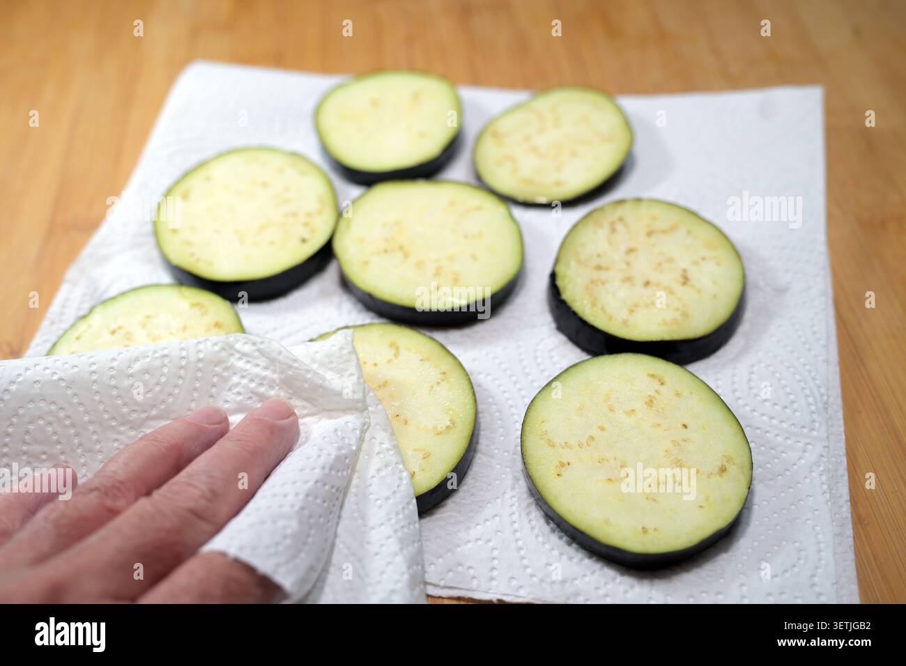 Le fette di melanzane salate sono state sudorate e rilasciate acqua, ora vengono asciugate con un tovagliolo di carta prima di ulteriore preparazione, tema di cottura, selec Foto Stock