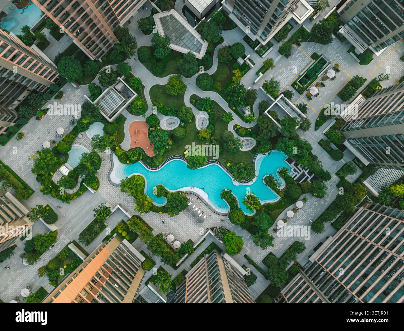 Vista aerea della moderna area residenziale con vegetazione, giochi d'acqua e spazi ricreativi in un ambiente urbano. Foto Stock