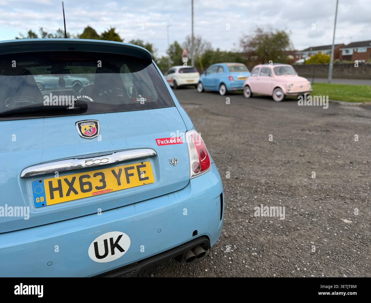 Vista posteriore di una fiat 500 e abarth 500 azzurra parcheggiata nel Regno Unito con altre auto fiat 500 classiche e moderne sullo sfondo - Immagine stock catturata con smartphone
