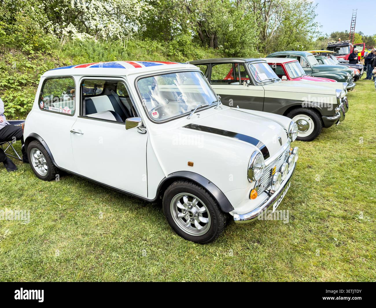 Mini Cooper bianca classica e veicoli d'epoca parcheggiati in una mostra all'aperto nel Regno Unito - Immagine stock catturata con smartphone