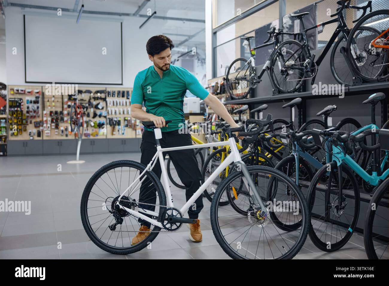 Il tecnico valuta la qualità e la precisione delle biciclette nell'ambiente retail Foto Stock