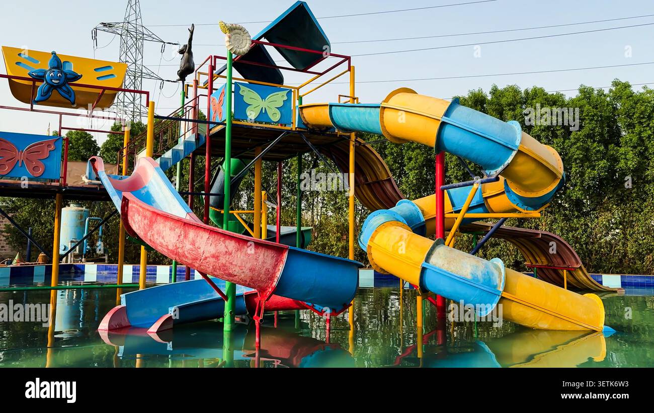 Parco divertimenti acquatico con coloratissime attrezzature da gioco e piscina tranquilla Foto Stock