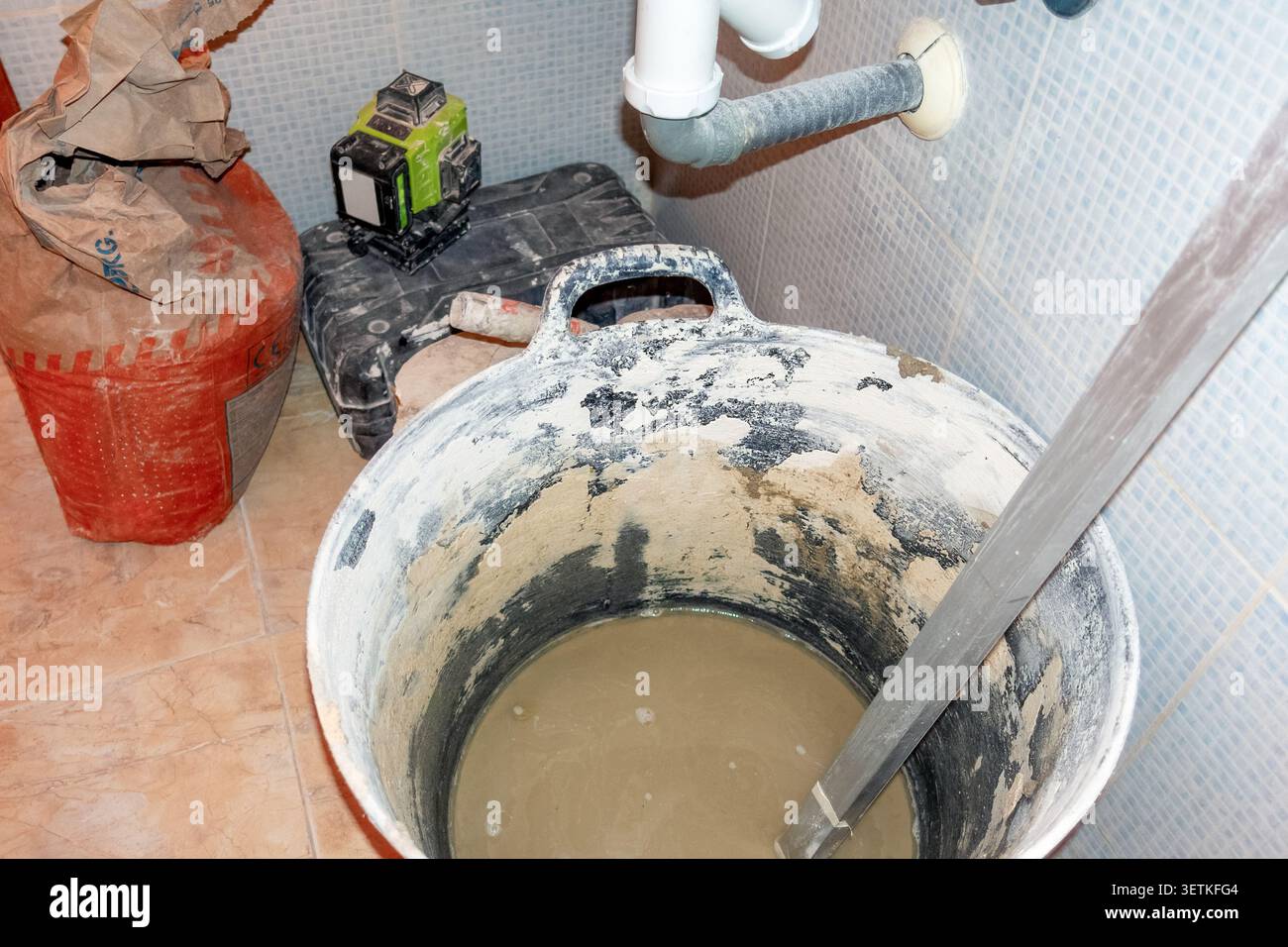 Materiali per la ristrutturazione del bagno con sacchetto per cemento e cassetta per utensili Foto Stock
