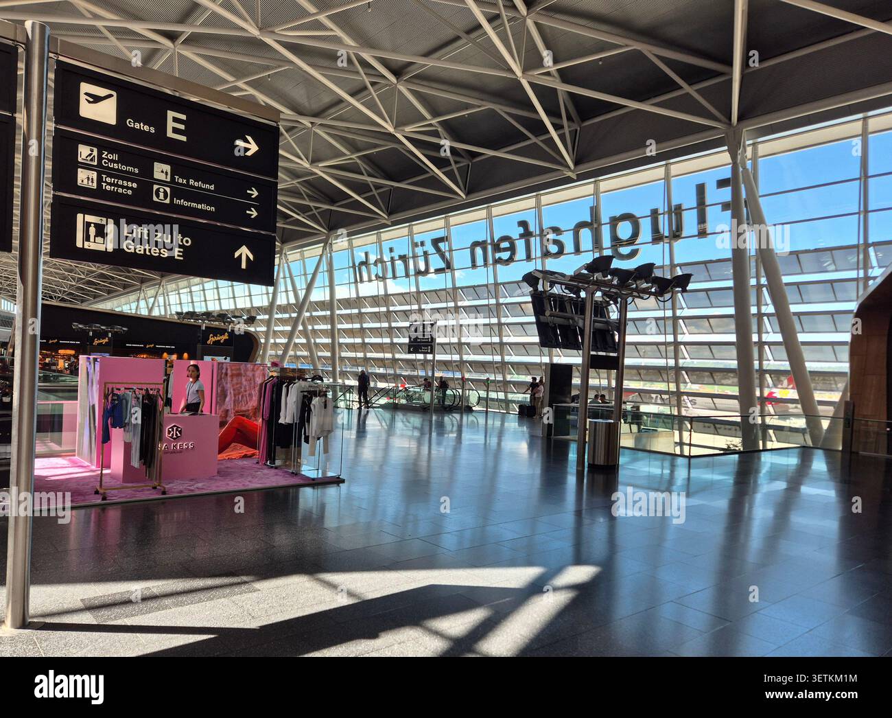ZURIGO, SVIZZERA - 14 GIUGNO 2026: Vista interna dell'aeroporto di Zurigo con passeggeri che camminano attraverso il moderno edificio del terminal. Foto Stock