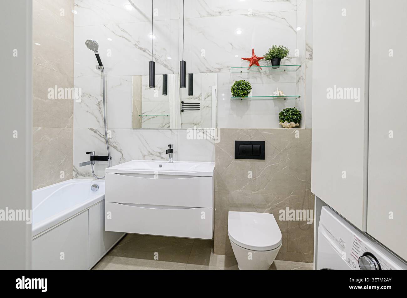 Bagno moderno con finiture bianche, piastrelle effetto marmo, eleganti dettagli neri e scaffali in vetro con elementi decorativi Foto Stock