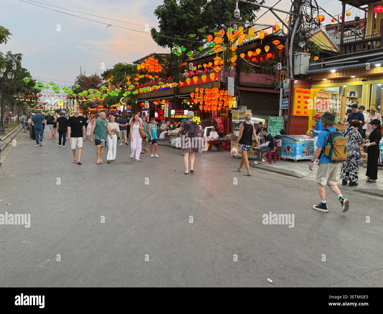 Al crepuscolo mentre i visitatori si radunano a Nguyen Phuc Chu, una lunga strada pedonale accanto al fiume Thu Bon nell'antica città di Hoi An nella provincia di Quang Nam, nel centro Foto Stock