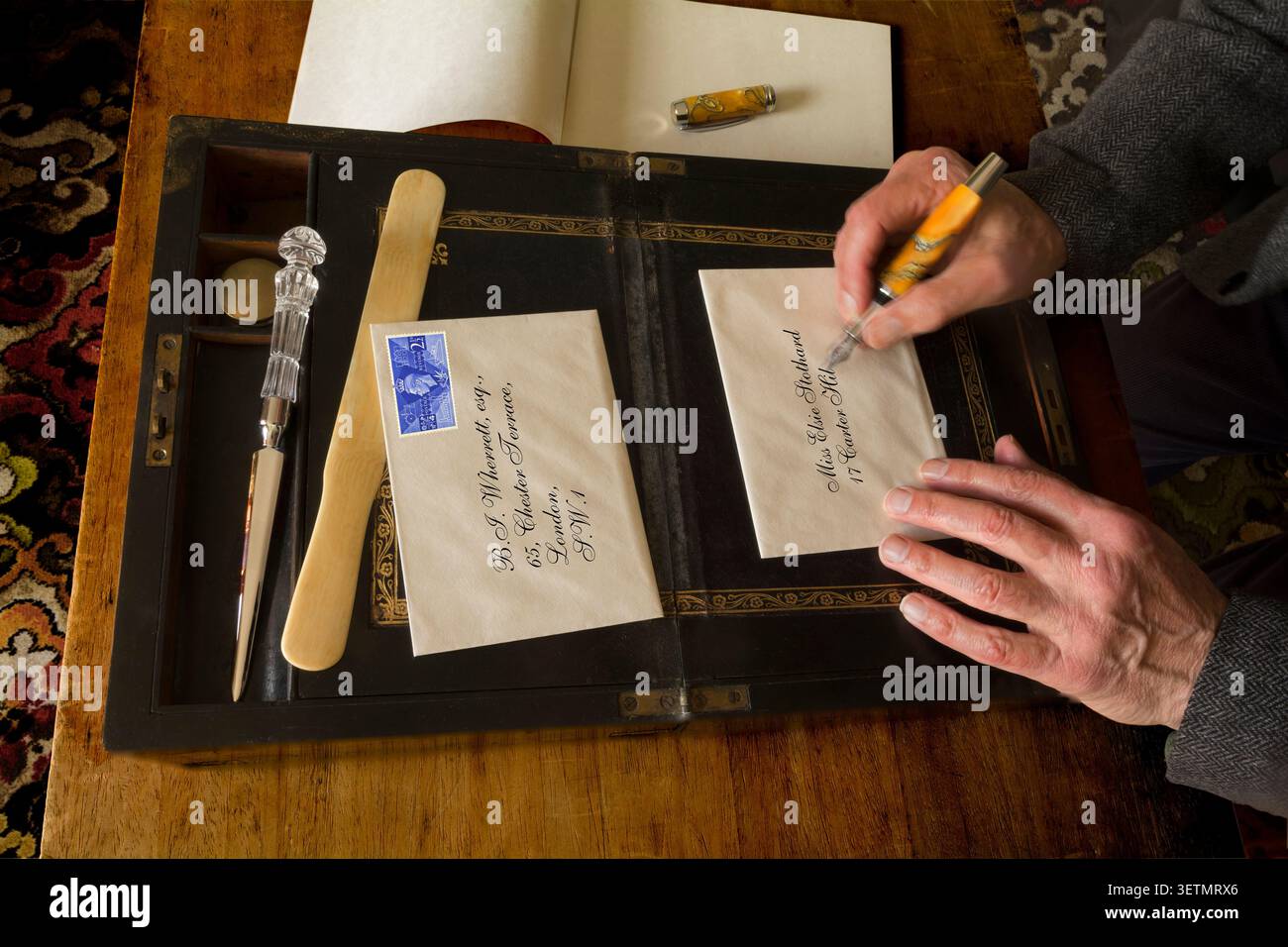 Scrivere una lettera a mano su una vecchia scatola per scrivere lettere Foto Stock