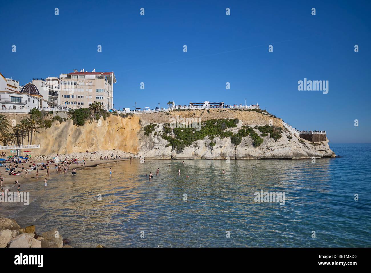 Spiaggia e scogliera panoramica con nuotatori. Benidorm, Alicante, Spagna - 5 aprile 2026. Foto Stock