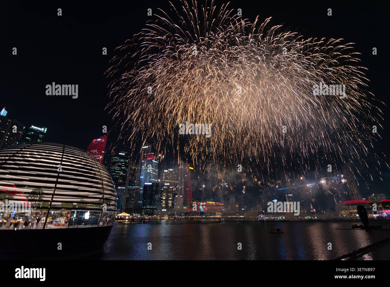 Fuochi d'artificio d'oro esplodono sulla città illuminata di Marina Bay di notte, Singapore Foto Stock