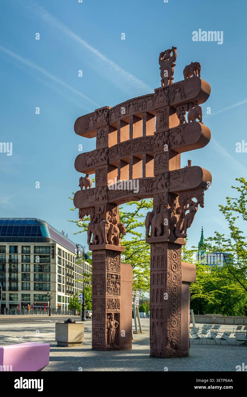 Berlino, Germania - 30 aprile 2025: La replica in pietra arenaria della porta Est di Sanchi si trova fuori dal Forum Humboldt, con una dettagliata auto buddista Foto Stock