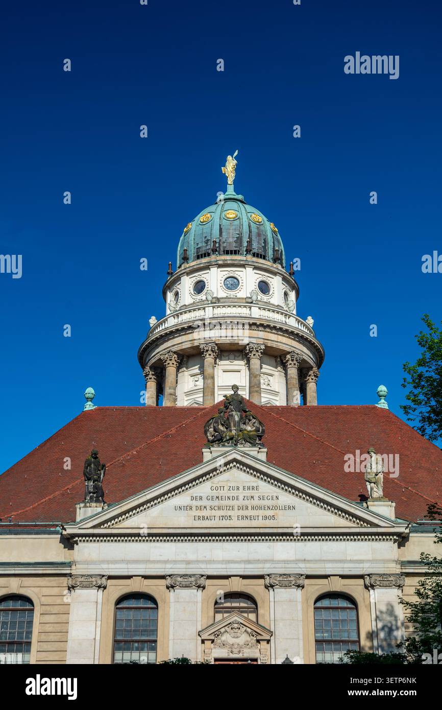 Vista ravvicinata della Cattedrale francese sul Gendarmenmarkt di Berlino, con la sua cupola verde, la statua dorata, colonne classiche e la facciata storica decorata Foto Stock