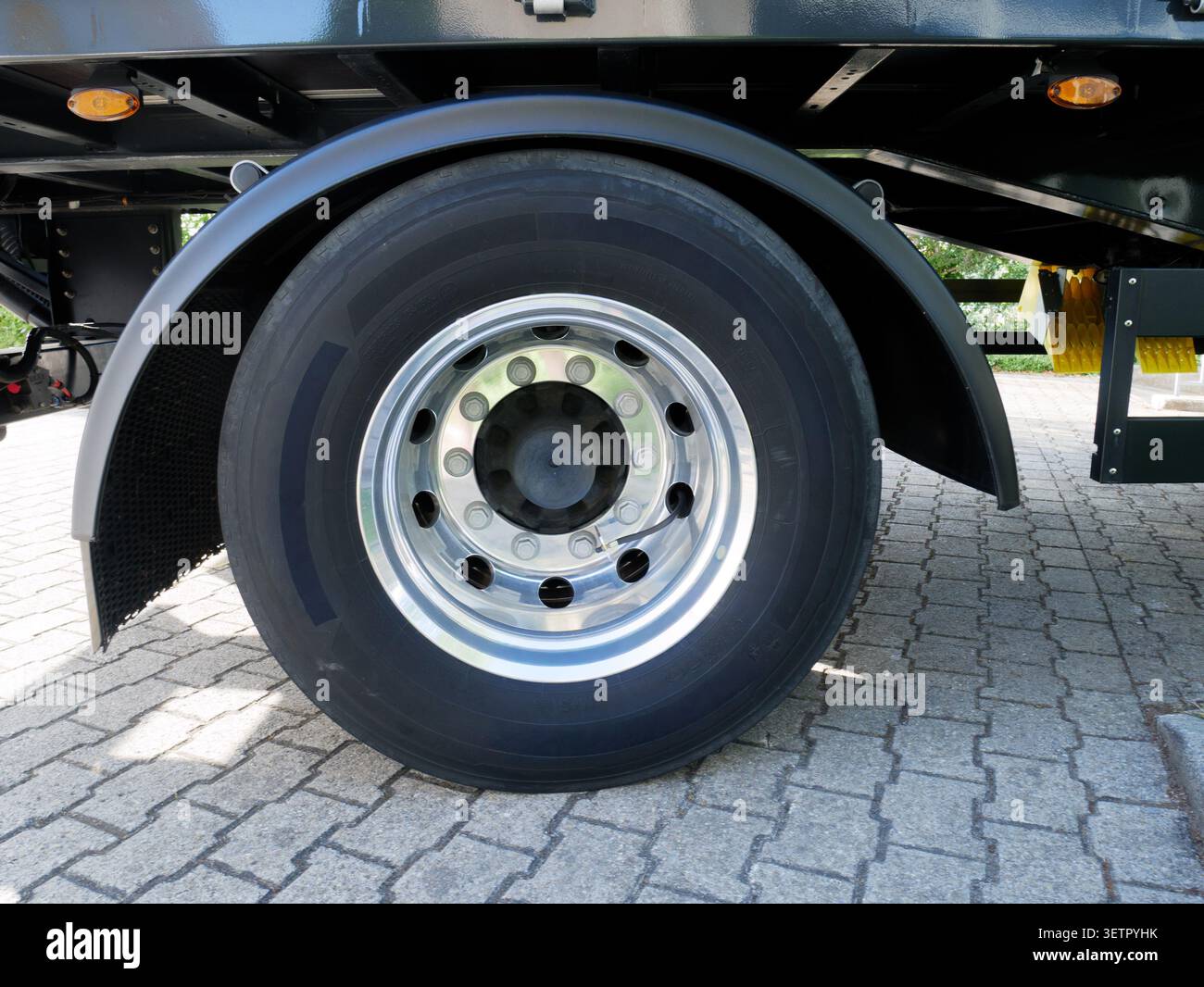 Primo piano della ruota per autocarri per impieghi gravosi su terreno pavimentato, attrezzature professionali per il trasporto logistico, servizio commerciale di trasporto merci su strada, manutenzione degli pneumatici Foto Stock