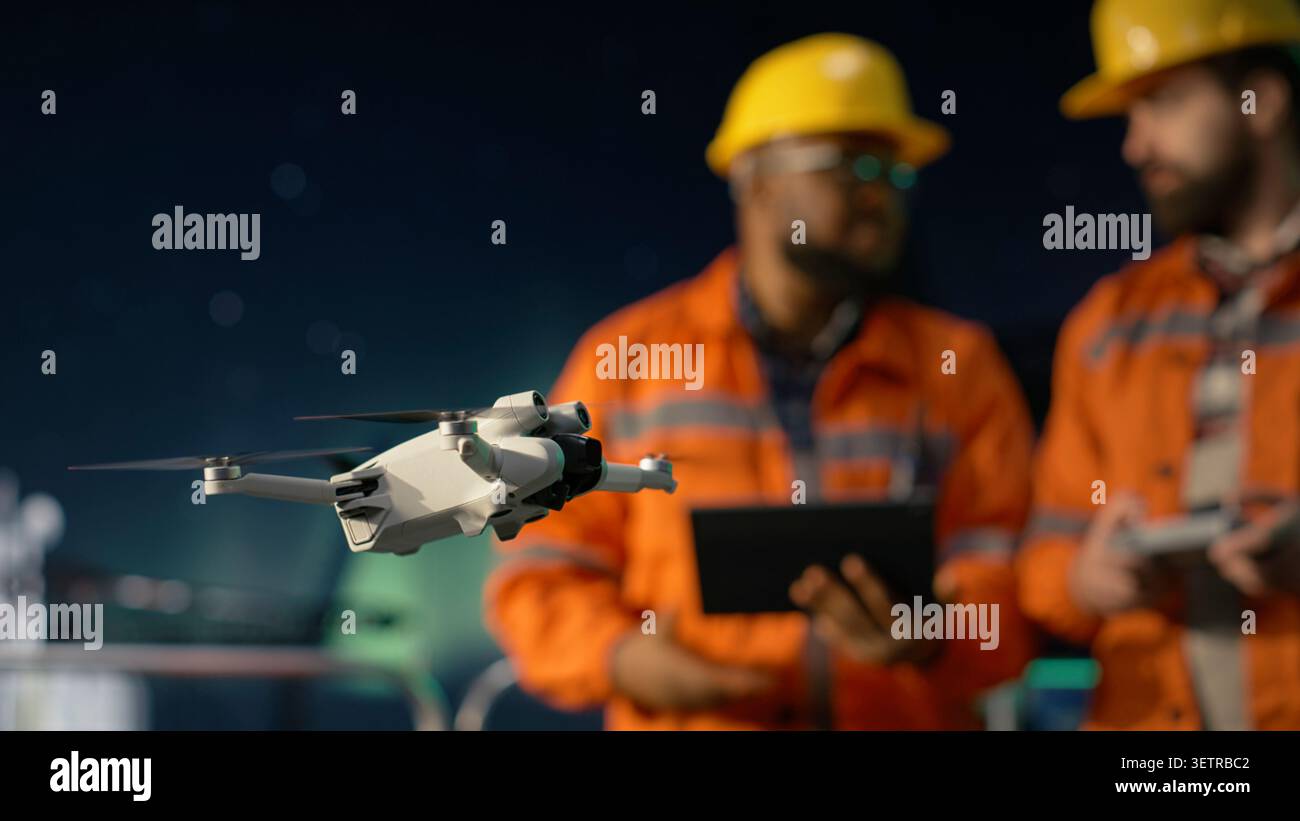Primo piano del drone utilizzato dagli uomini sulla piattaforma offshore per evitare il blocco del transito per l'ispezione del sito. I lavoratori dei carri di perforazione utilizzano UAV per determinare le posizioni ottimali per le condutture durante le crisi petrolifere, telecamera A. Foto Stock