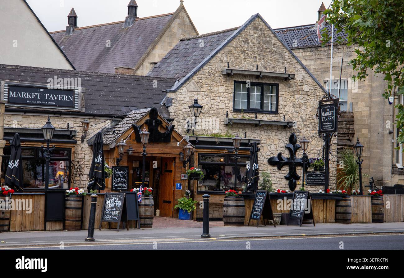 Tradizionale edificio in pietra del pub Market Tavern nella pittoresca cittadina inglese di Melksham con botti di legno e posti a sedere all'aperto Foto Stock