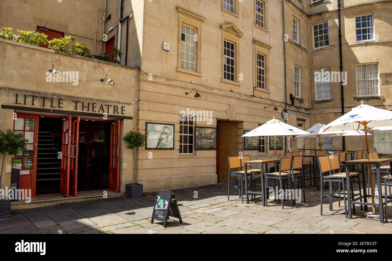 Ingresso al Little Theatre di Bath, Regno Unito, in uno storico edificio in pietra calcarea con un'area salotto all'aperto con tavoli e ombrelloni bianchi Foto Stock
