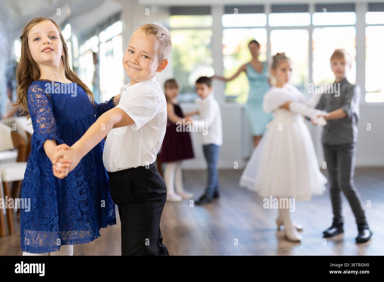 Entusiasti bambini preadolescenti che ballano valzer a coppie nella scuola di danza Foto Stock