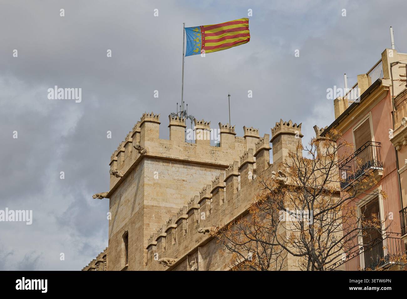 La bandiera spagnola vola su un edificio storico con una torre. Foto Stock