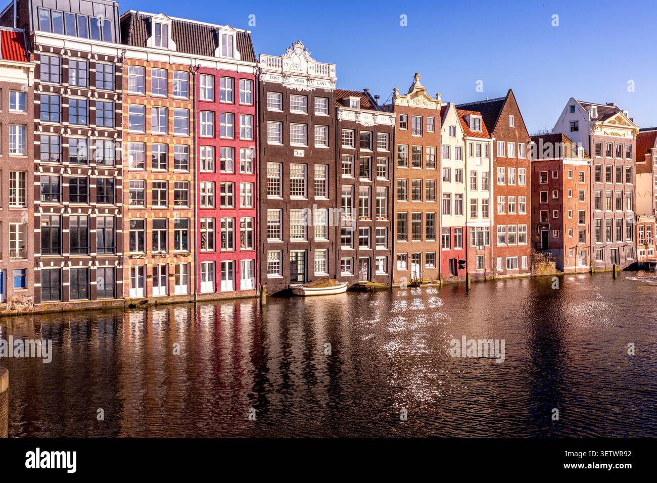 Amsterdam, Paesi Bassi - 22 aprile 2024: Damrak, il vivace cuore di Amsterdam, dove edifici storici, canali e vita cittadina creano il perfec Foto Stock