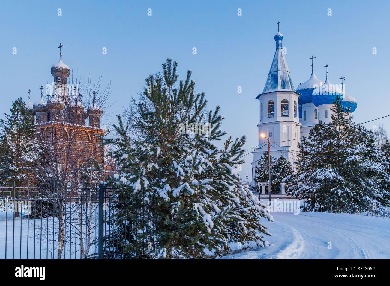 La chiesa in pietra di Sretenskaya si trova accanto alla chiesa di legno di Pokrovsky. Le loro cupole si riflettono nel blu della mattina presto. Foto Stock