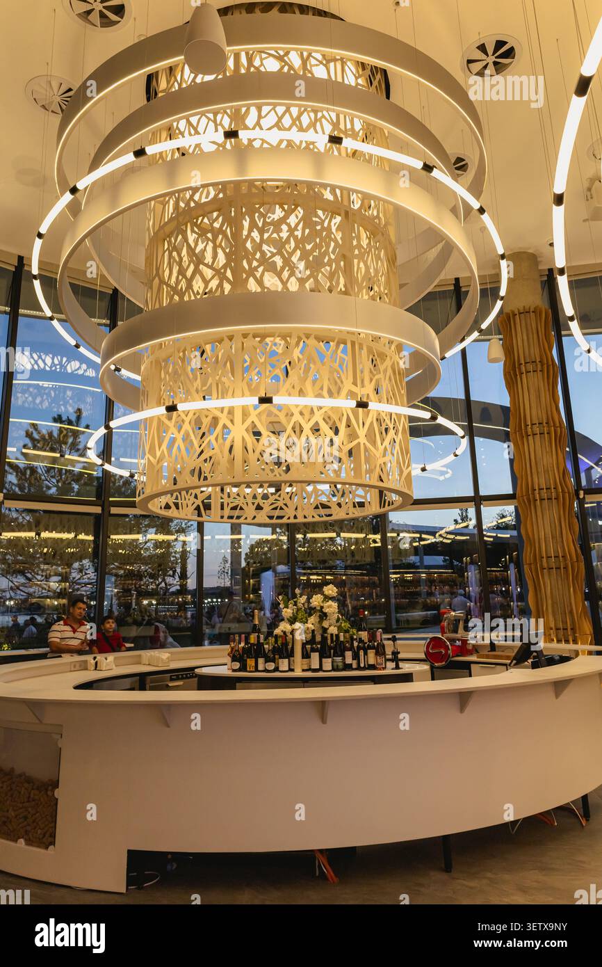 Gelendzhik, Russia - 14 giugno 2026: Apertura della città del vino di Capo bianco. Gli interni moderni del wine bar presentano un elegante bancone circolare con bottiglie di vino, Foto Stock