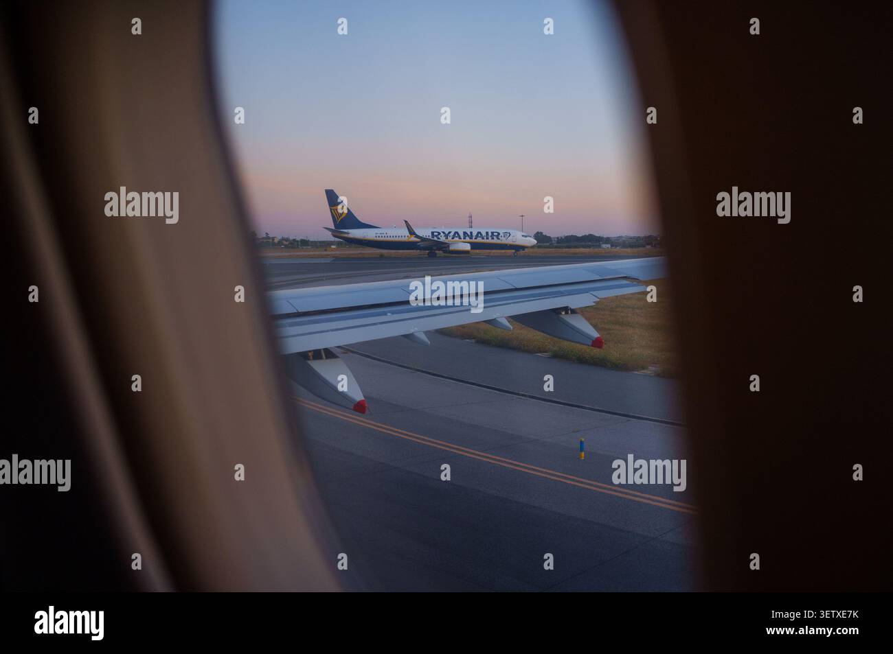 Un aereo Ryanair si prepara a guardare attraverso la finestra di un altro aereo durante il decollo. Foto Stock