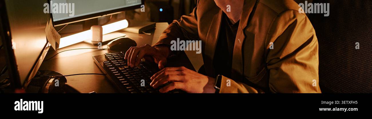 Intestazione dell'uomo adulto che lavora al computer durante il turno di notte in ufficio Foto Stock
