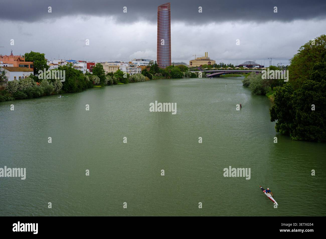 La Torre di Siviglia e il fiume Guadalquivir sono travolti da un'enorme pioggia di fronte alla nuvola nera scura che si muove verso la città. Foto Stock
