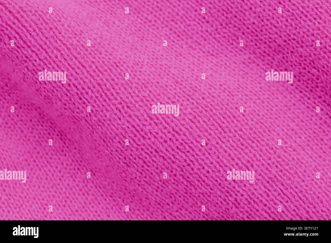 Sfondo macro-shot full-frame con una vivace trama in maglia rosa, che mette in risalto i dettagli delle cuciture interlacciate e il morbido motivo a coste della y Foto Stock