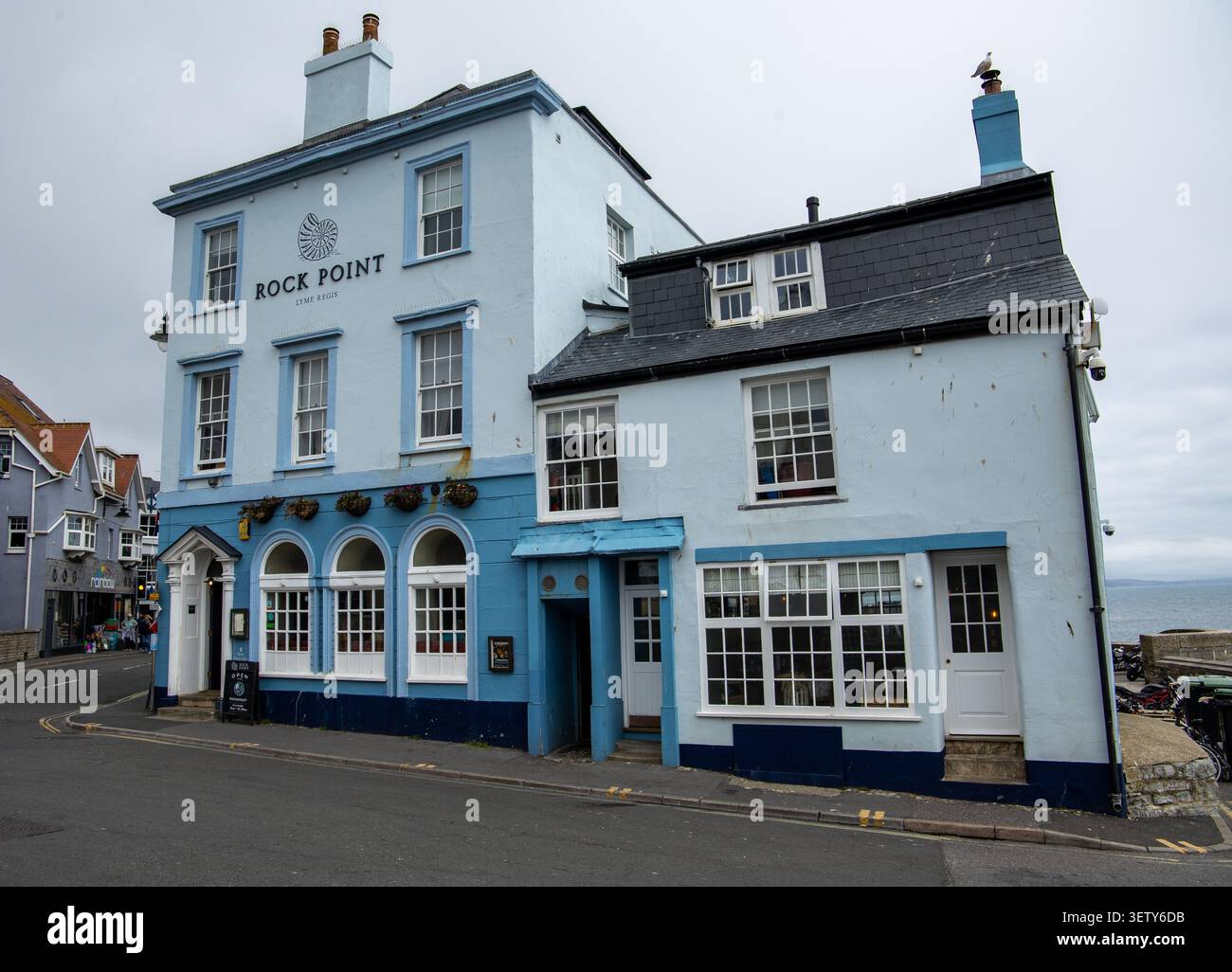 Lo storico Rock Point inn con pareti dipinte di blu chiaro si trova nella città costiera di Lyme Regis Foto Stock