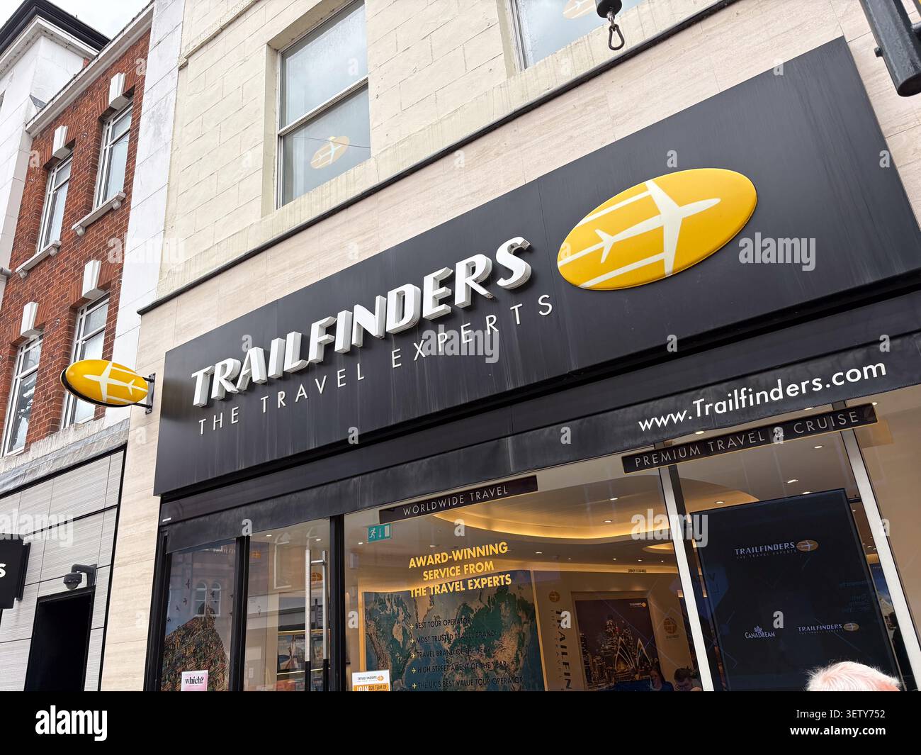 Negozio esterno dell'agenzia di viaggi Trailfinders. Leeds, Regno Unito. Facciata commerciale con logo giallo dell'aereo e vetrine in vetro. Foto Stock