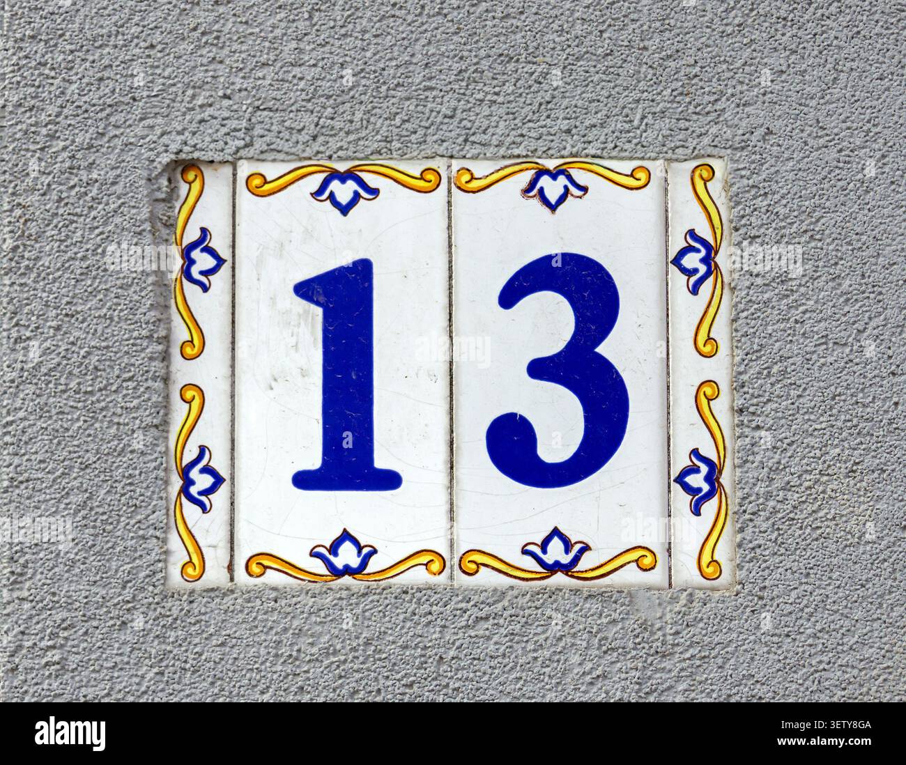 Numero 13 sull'indirizzo della casa con piastra metallica sulla parete della facciata esterna Foto Stock