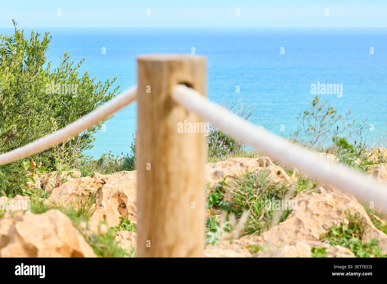 Palo di recinzione in legno con corda sulla scogliera costiera Spagna. Foto Stock