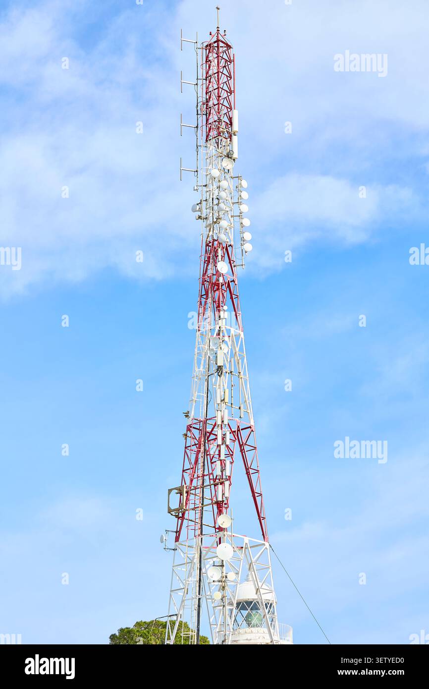 Torre di comunicazione rossa e bianca con antenne e piatti. Foto Stock