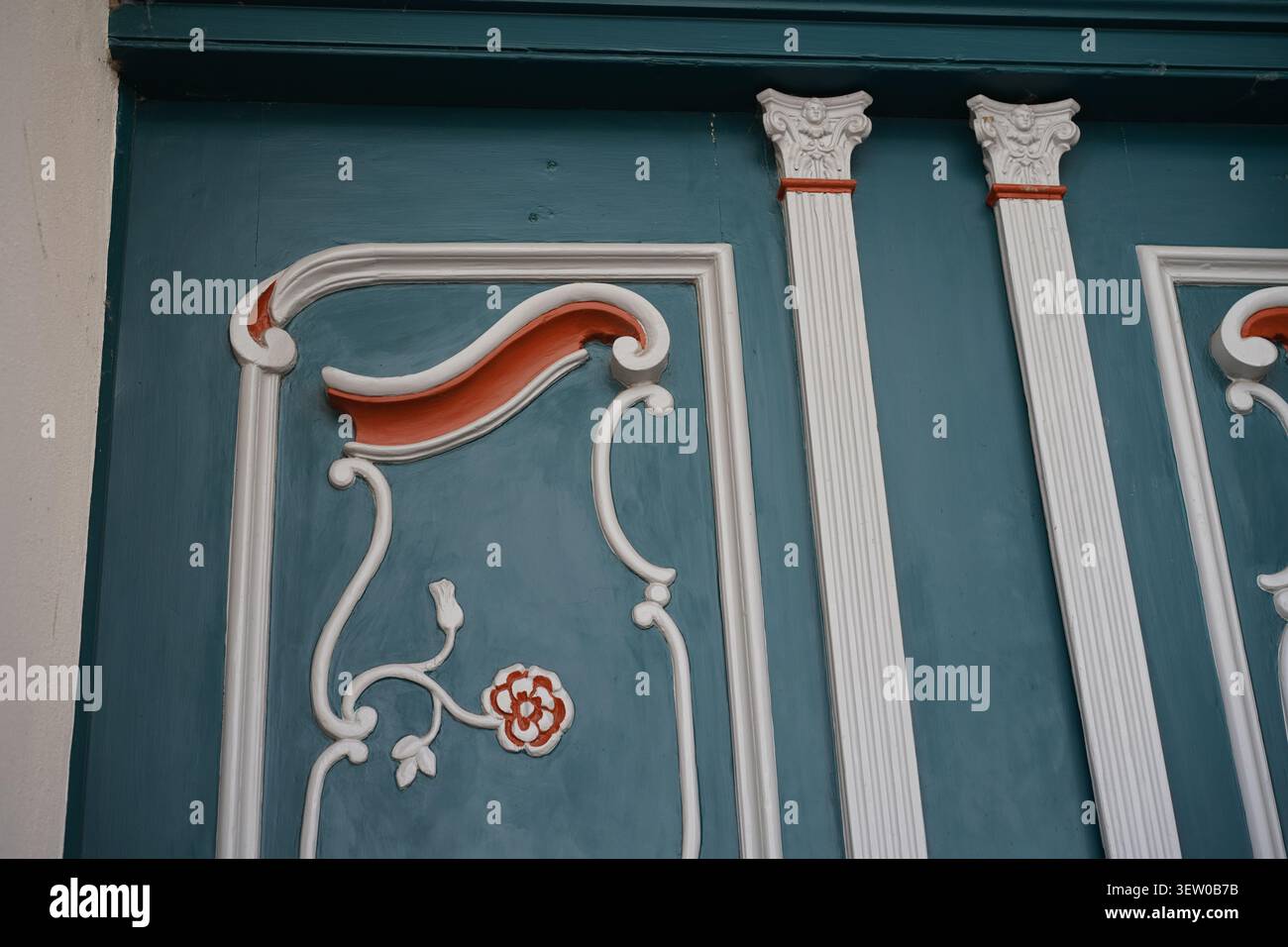 Dettaglio architettonico di una porta in legno in stile storicismo con intagli rococò, pilastri e ornamenti floreali a Stralsund, Germania. Foto Stock