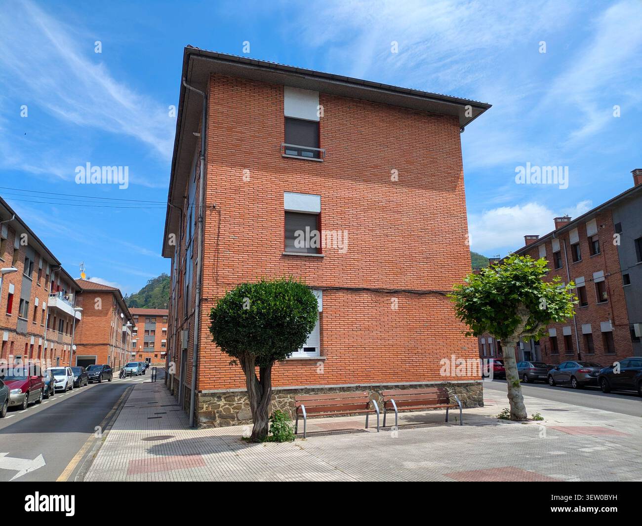 EIBAR, SPAGNA - 25 MAGGIO 2025: Una strada tranquilla a Eibar, Spagna, fiancheggiata da edifici in mattoni, auto parcheggiate e lavanderia appesa alle finestre sotto Foto Stock