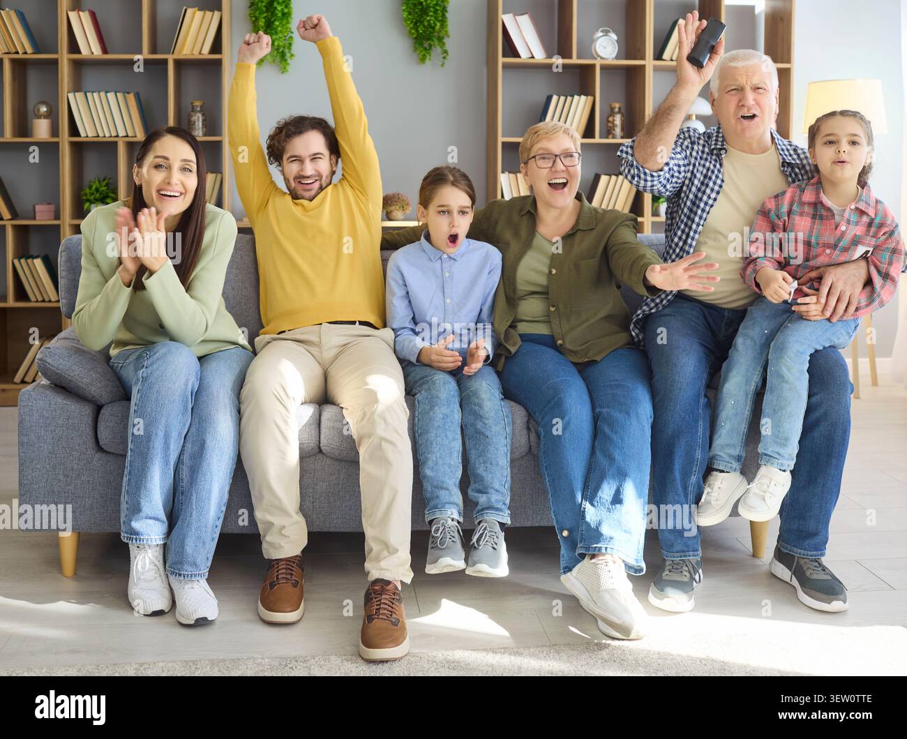 Allegra famiglia con nonni e bambini che guardano le partite di sport insieme a casa Foto Stock