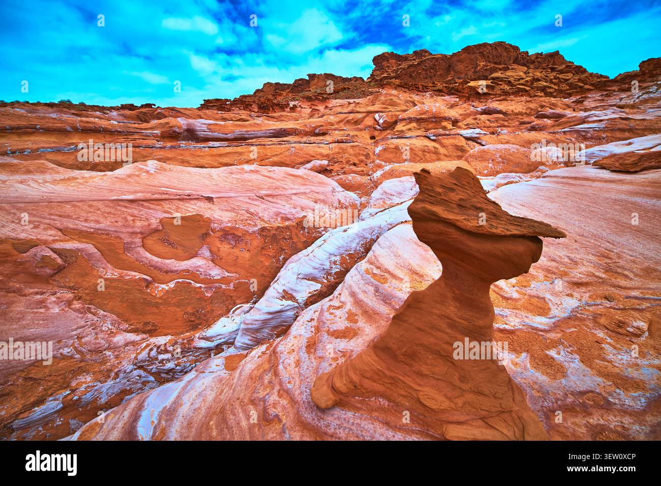 Formazione di arenaria scolpita dal vento e rocce rosse a strati sotto il cielo blu Foto Stock