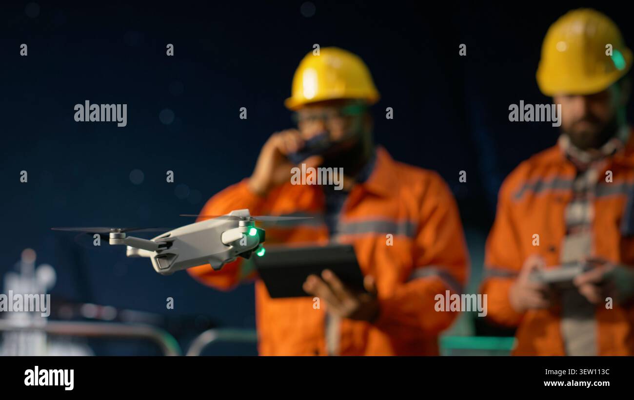 Schivare il blocco del transito, ravvicinare i droni e gli uomini sulla piattaforma offshore che effettuano ispezioni in loco. Determinazione della posizione ottimale delle condutture, delle crisi petrolifere e dei lavoratori dei carri di perforazione utilizzando UAV, telecamera A. Foto Stock