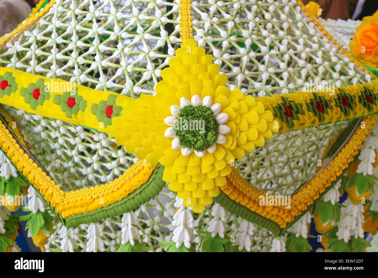 Primo piano di un tradizionale lampadario floreale thailandese con motivo a stella gialla, un autentico ornamento fatto a mano per una spa di lusso e un arredamento per matrimoni. Foto Stock