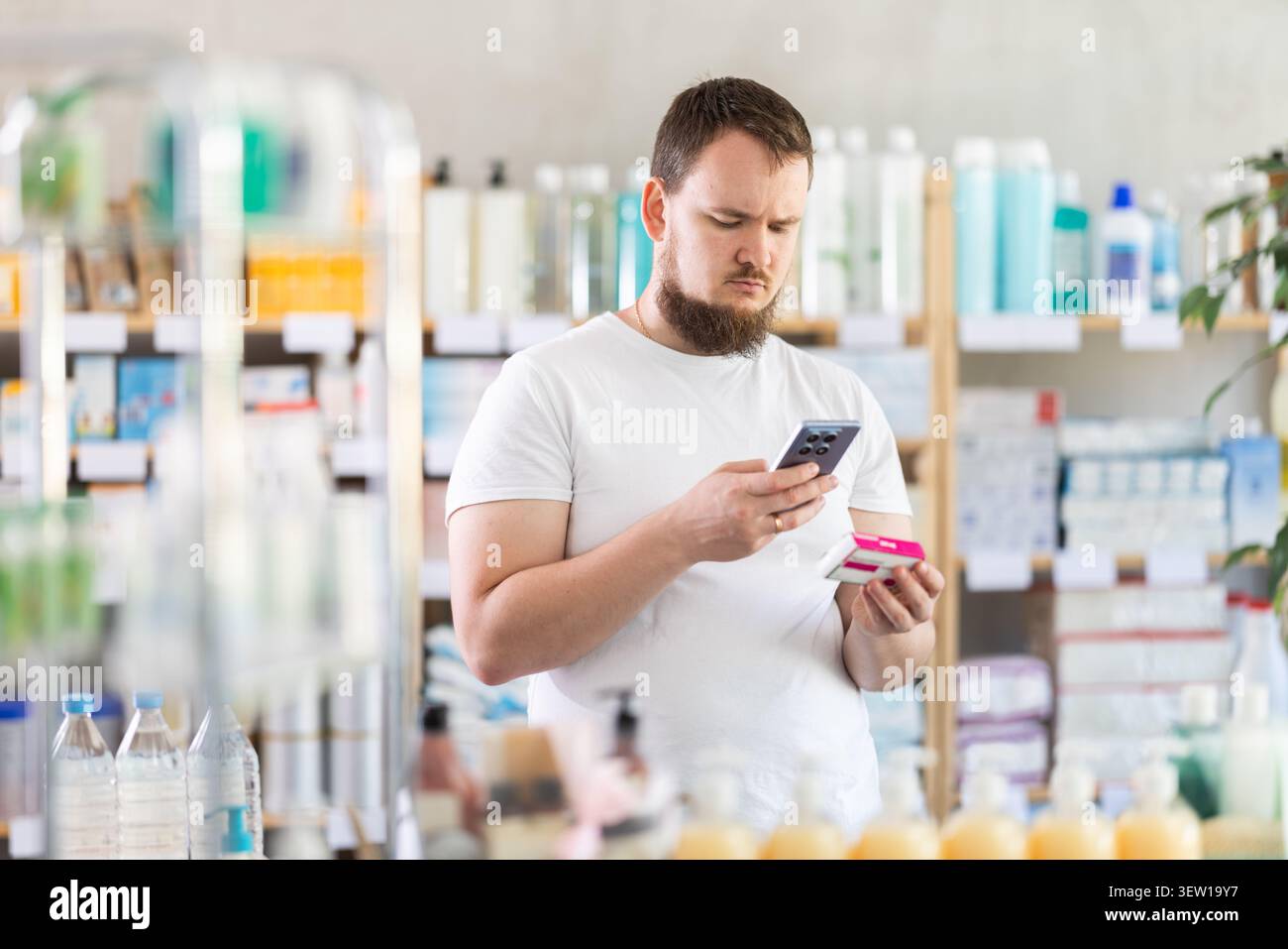 Man esegue la scansione del codice sulla confezione delle pillole di paracetamolo per controllare la data di scadenza Foto Stock