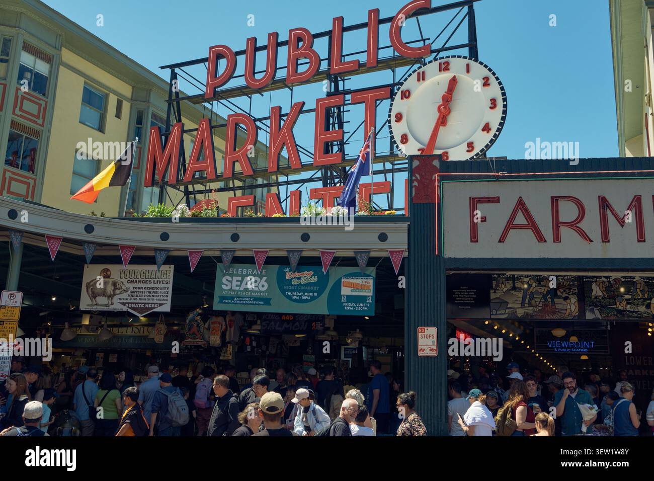 Pike Place Market a Seattle, Washington, con bancarelle affollate, cartelloni vivaci e folle vivaci che catturano l'atmosfera iconica di questa storica città Foto Stock