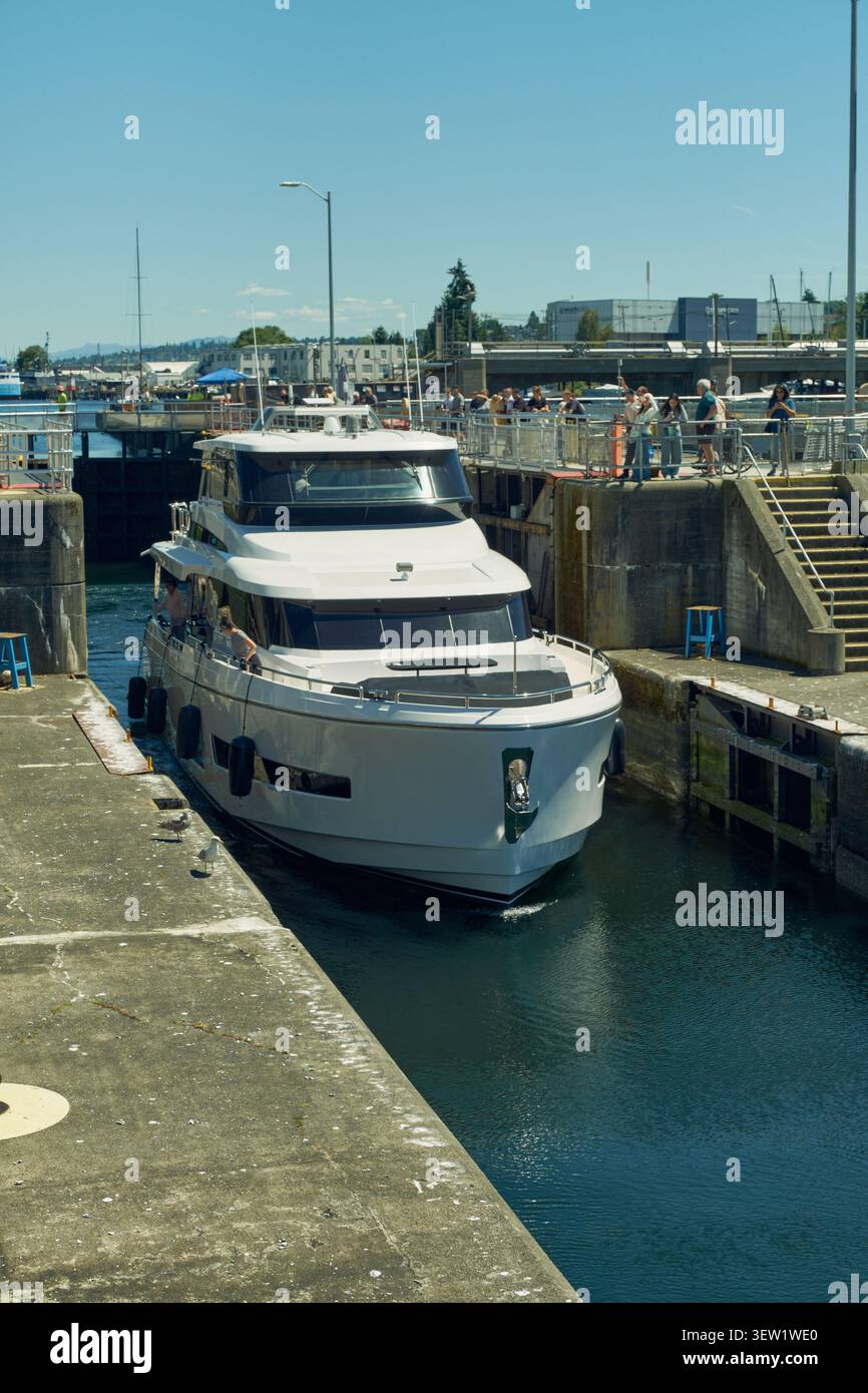 Le storiche Ballard Locks di Seattle, Washington, mostrano le barche che navigano nel sistema dei canali tra i panoramici dintorni del Pacifico nord-occidentale e il vivace flusso d'acqua Foto Stock