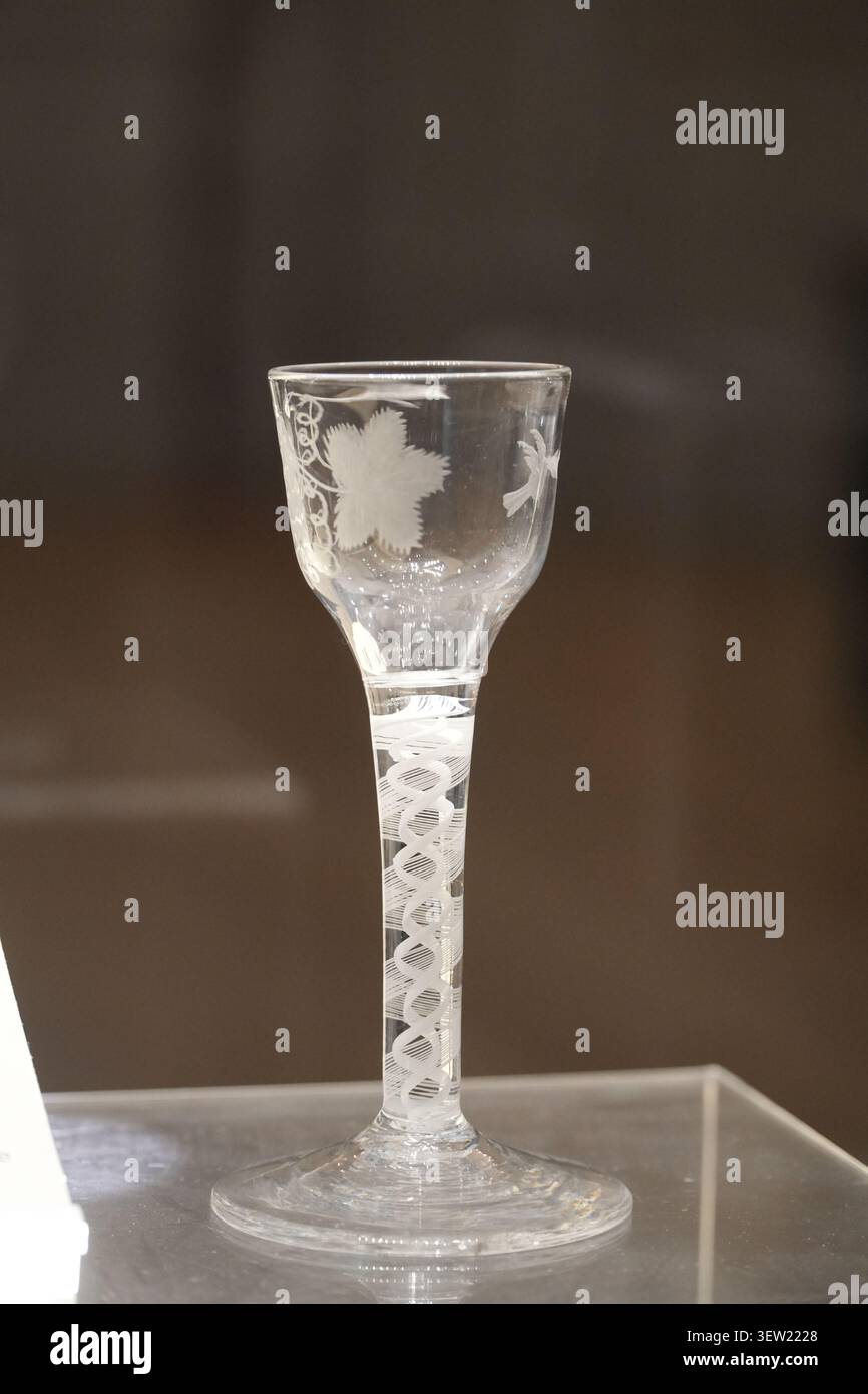 Un bicchiere di vino inglese del XVIII secolo caratterizzato da un ornato fusto ad aria e motivi di vite incisi, in mostra in Inghilterra. Foto Stock