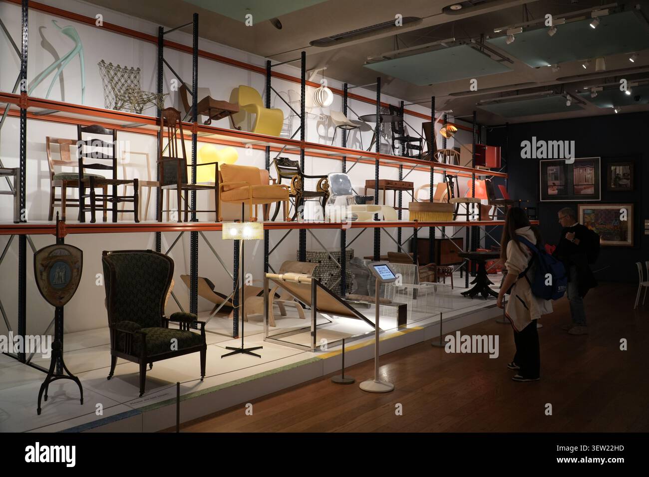 Collezione museale di sedie vintage e di design su scaffali industriali. Manchester, Regno Unito. Foto Stock