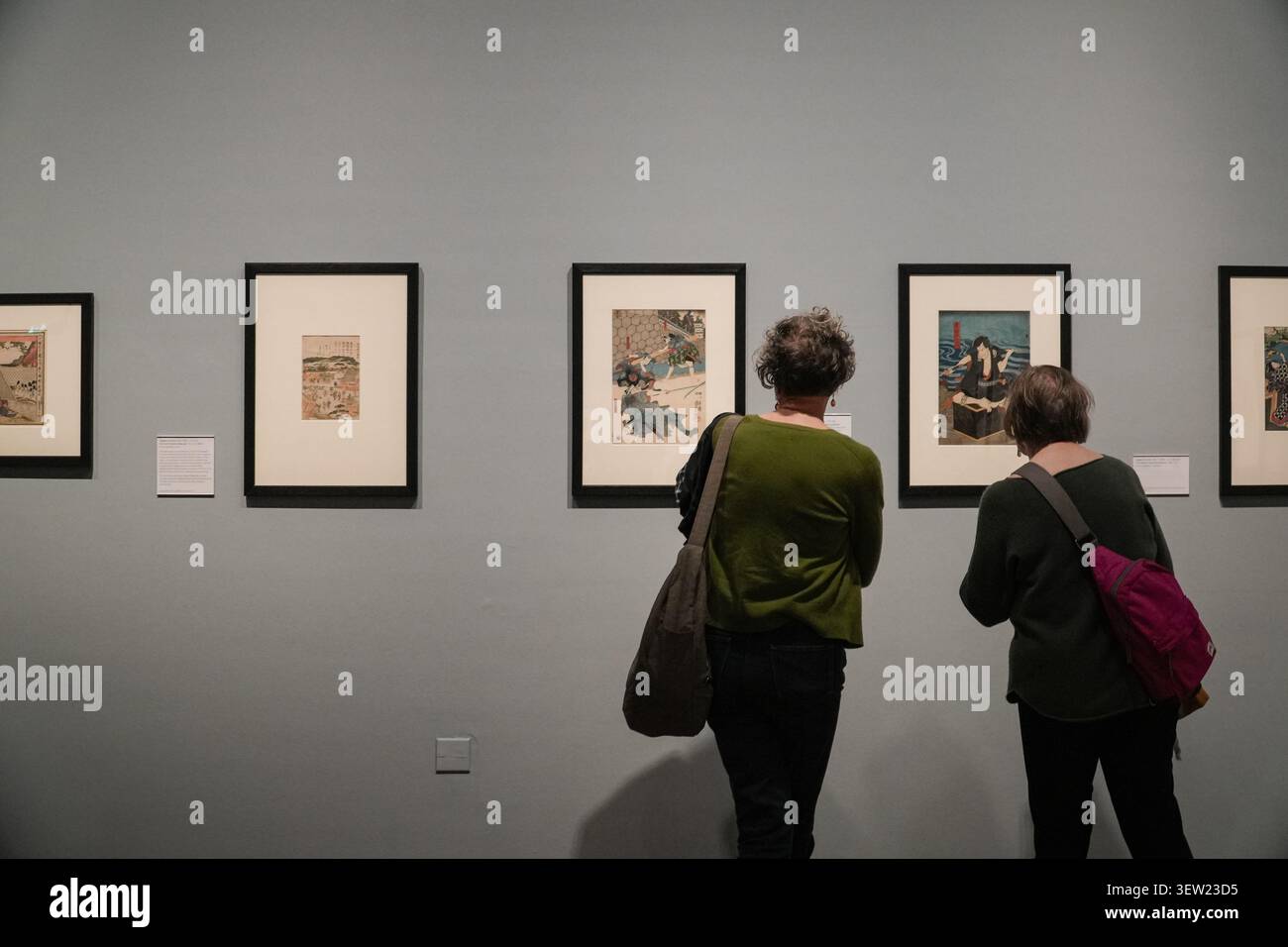 Due donne che guardano stampe ukiyo-e giapponesi incorniciate nello spazio della galleria di Whitworth, Manchester, Regno Unito. Foto Stock