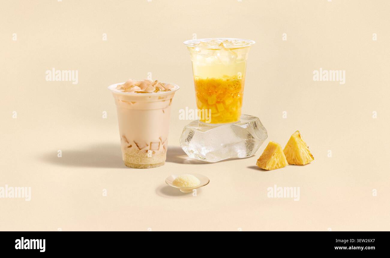 Tè freddo ai frutti di ananas e tè al latte con guarnizione di gelatina su blocco di ghiaccio Foto Stock