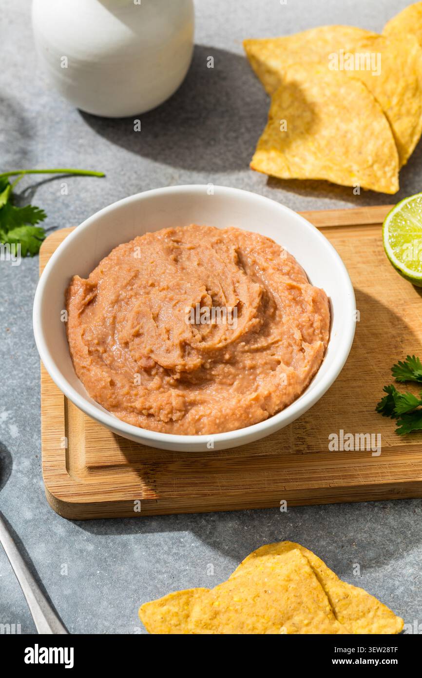 Fagioli fritti biologici messicani fatti in casa con lime e patatine alla tortilla Foto Stock