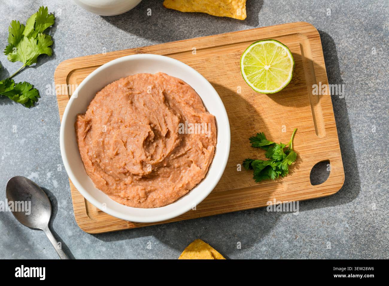 Fagioli fritti biologici messicani fatti in casa con lime e patatine alla tortilla Foto Stock