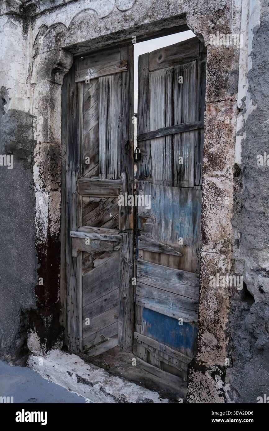 Porta di legno intemprata in un edificio nelle isole greche. Foto Stock